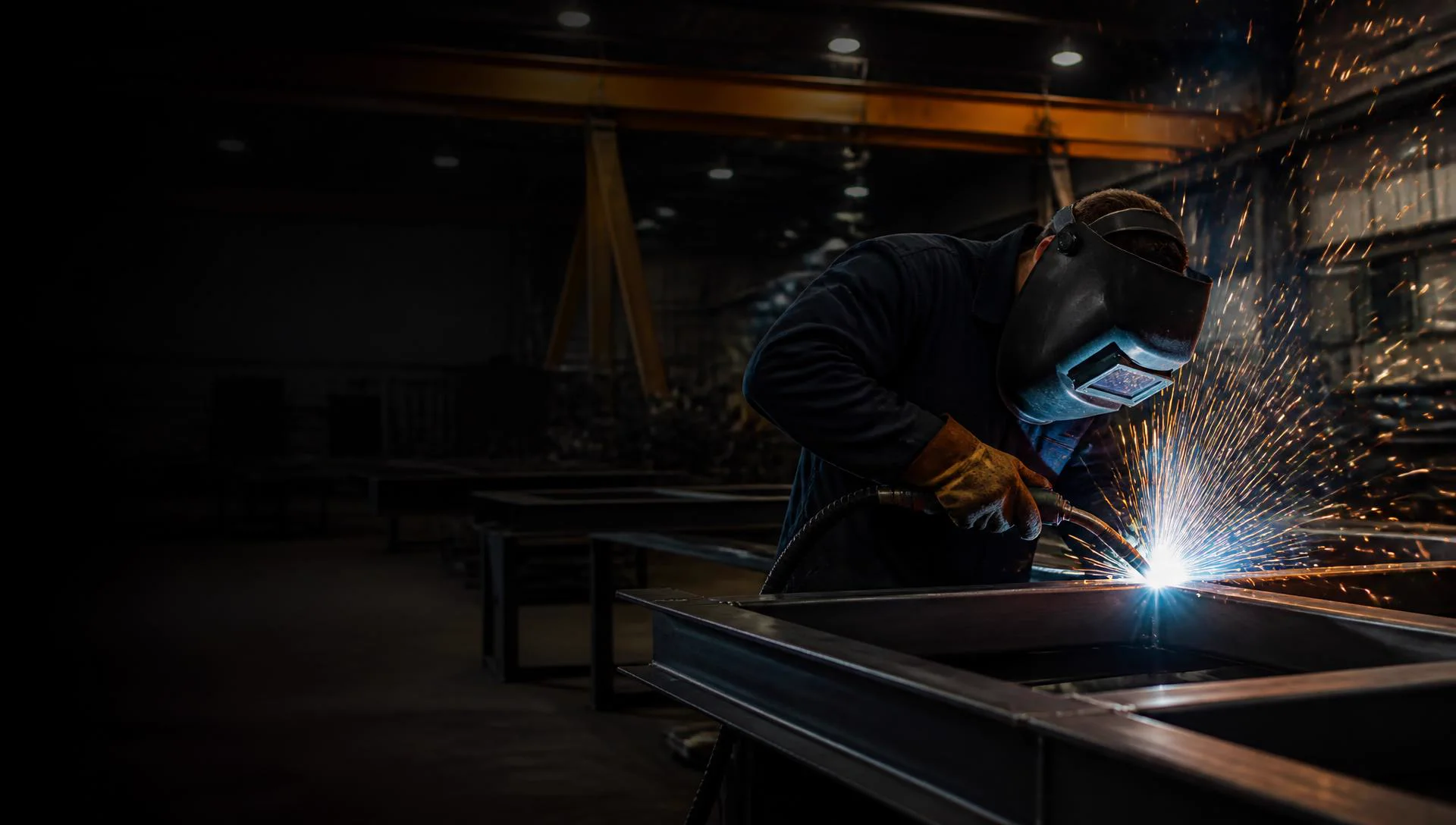 Welder laying a bead on a steel frame in the Miller's shop